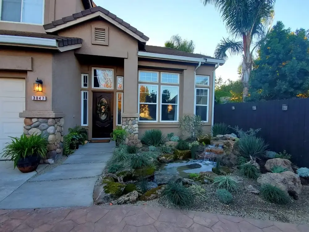 Front-yard stream and rock garden framing a home entry