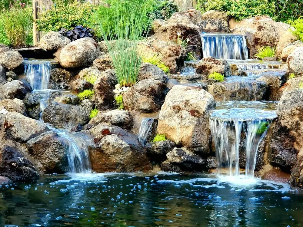 Multi-tier boulder waterfall spilling into clear pools