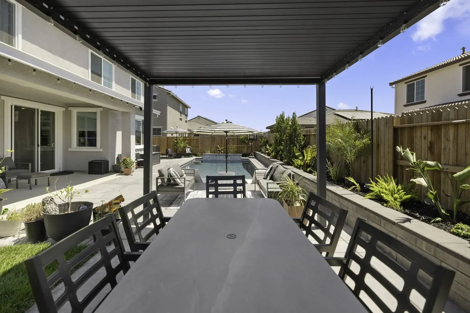 Covered outdoor dining area looking out to the pool