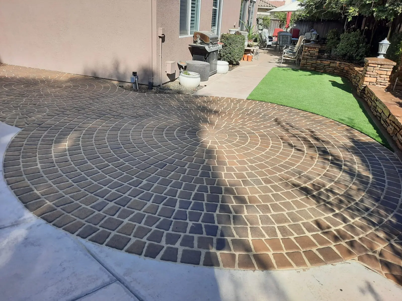 Synthetic grass lawn with circular paver inlay