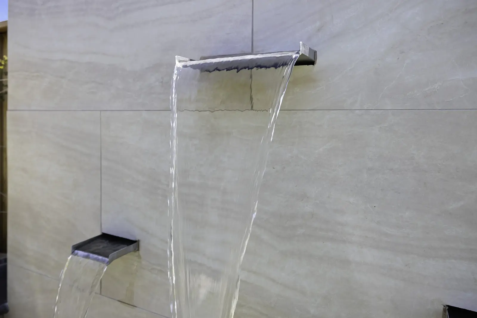 Modern architectural water wall with a single sheet spillway