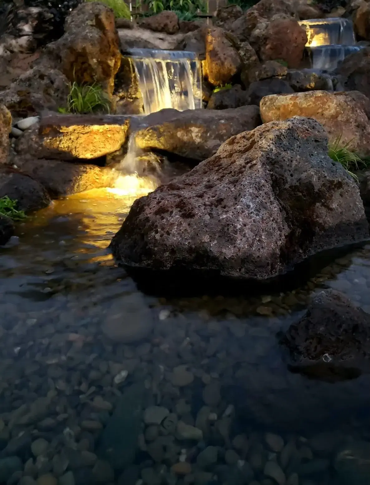 Boulder waterfall lit warmly at night